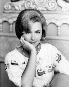 an old black and white photo of a woman with her hand on her chin looking at the camera