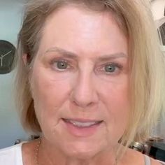 an older woman with blonde hair and blue eyes is looking at the camera while wearing a necklace