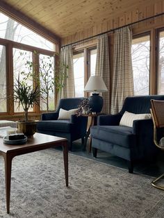 a living room filled with furniture and large windows