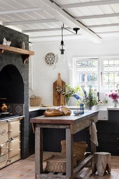 a kitchen with an oven, stove and table in front of the counter top is decorated with flowers