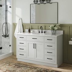 a bathroom with a sink, mirror and shower stall in the middle of the room