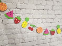 paper fruit garland hanging on a brick wall