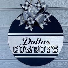 a sign that says, dallas cowboys hanging on the side of a building with a bow