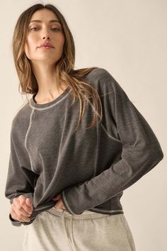 Solid ribbed knit top. Round neckline. Long raglan sleeves. Contrast stitching throughout. Relaxed fit. 67% Polyester, 29% Cotton, 4% Spandex. Imported. Designed in LA. Model wears size S. Gray Ribbed Top For Fall, Fall Gray Ribbed Top, Ribbed Crew Neck Athleisure Top, Stretch Ribbed Gray Tops, Everyday Athleisure Tops With Thumbholes, Stretch Textured Knit Top For Loungewear, Fall Athleisure Tops With Raglan Sleeves, Sporty Knit Tops For Fall, Relaxed Fit Raglan Sleeve Tops For Layering