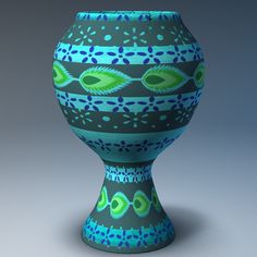 a blue and green vase sitting on top of a table