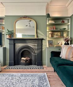 a living room with a couch, fireplace and bookshelf in the middle of it