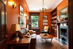 a living room with orange walls and furniture