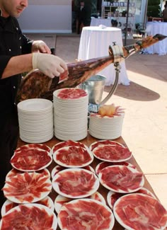 a man preparing food on top of a wooden table