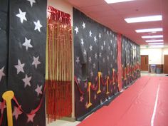 an empty hallway with red carpet and black curtained walls, decorated with white stars