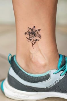 a woman's foot with a small flower tattoo on the side of her ankle