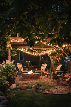 The image showcases a beautifully lit backyard featuring string lights draped across a wooden pergola, creating a warm and inviting atmosphere. The setup includes comfortable seating around a fire pit, surrounded by lush greenery and a pathway made of stone slabs leading through the garden. The ambiance is enhanced by the strategic placement of lights, making the space perfect for evening gatherings and relaxation. Garden Pergola Fire Pit, Small Backyard With Deck Ideas, Country House Outdoor Ideas, Backyard Deck Lighting Ideas, Fireplace Backyard Ideas, Diy Farm Decor, Backyard Ideas Plants, Woodsy Backyard Ideas, Deck Ideas Decorating