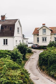 two white houses sitting on the side of a road