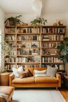 a living room filled with lots of bookshelves next to a couch and chair