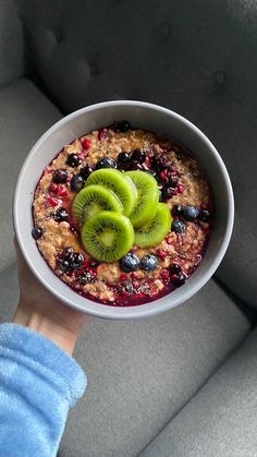 a bowl of oatmeal with kiwi slices and blueberries in it