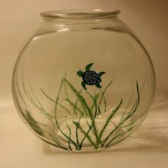 a fish bowl with seaweed and a turtle in it