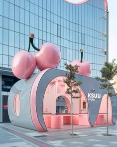 a pink and white building with cherry shaped decorations on it's front entrance area