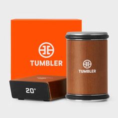 the tumbler is in front of an orange box and it's packaging next to it