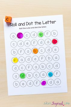 roll and dot the letter worksheet on a wooden table with orange dices