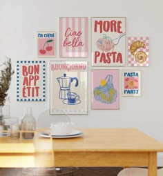 a wooden table with plates and cups on it in front of a wall full of posters