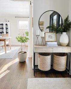 a living room filled with furniture and a mirror on top of a wooden table next to a doorway