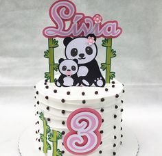 a white cake with a panda bear on top and pink number two in the middle