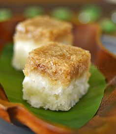 two pieces of cake sitting on top of a green leaf covered plate with leaves around it