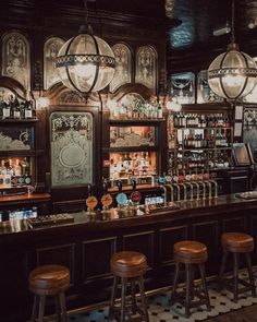 a bar with stools and lights hanging from the ceiling