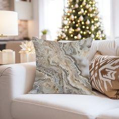 a living room with a white couch and christmas tree in the backgroung