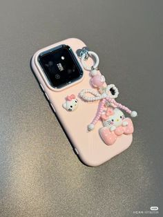 an iphone case with hello kitty on it and a keychain attached to the back