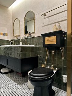 a black toilet sitting next to a white sink in a bathroom under a large mirror