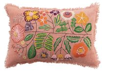 a pink pillow with flowers and leaves embroidered on the front, sitting on a white surface