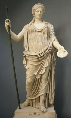 a statue of a woman holding a staff