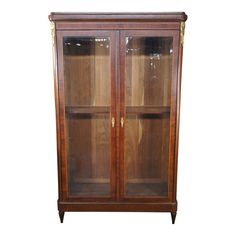 an antique bookcase with glass doors and gold trimmings on the top shelf