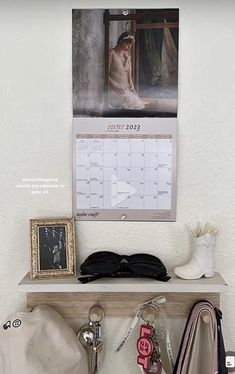 there is a calendar on the wall next to some purses and other personal items