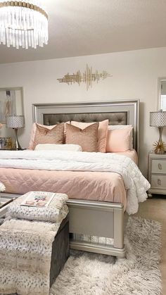 a bedroom with a bed, ottoman and chandelier