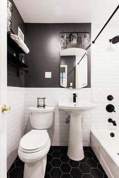 a white toilet sitting next to a bath tub in a bathroom under a sink mirror