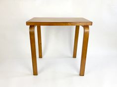 a small wooden table sitting on top of a white floor