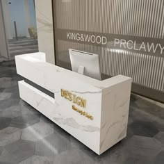 the reception desk is white and has gold lettering on it