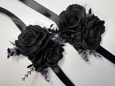 two black sashes with purple flowers and leaves on them are laying next to each other