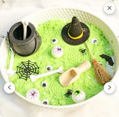 a bowl filled with green liquid and halloween decorations