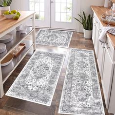 three rugs in the middle of a kitchen with plates and bowls on the counter