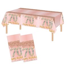 a pink table cloth with the number seventy on it and two napkins underneath it