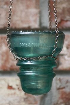 a green glass bowl hanging from a chain