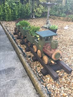 a train made out of logs sitting on top of gravel