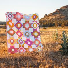 a quilt is laying in the middle of a field