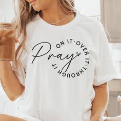 Strengthen your faith with our Pray On It, Over It, Through It shirt. Featuring the encouraging phrase "Pray On It, Over It, Through It" in elegant lettering, this shirt is perfect for those who find strength and comfort in prayer. Ideal for casual wear or as a thoughtful gift for friends and family who cherish their faith. Encouraging Phrases, Pray On It, Uplifting Phrases, The Power Of Prayer, Faith Tees, Inspirational Tees, Inspirational Design, Faith Shirt