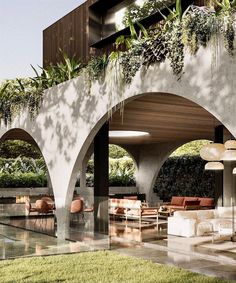 an outdoor area with tables, chairs and potted plants on the wall next to a swimming pool