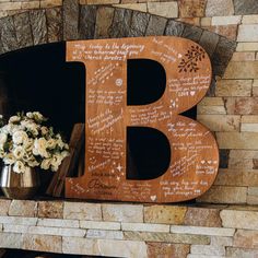 a large wooden letter sitting on top of a fireplace