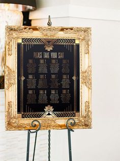 a black and gold wedding seating chart on a easel