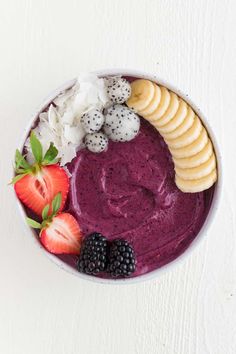 a bowl filled with fruit and yogurt on top of a white tablecloth